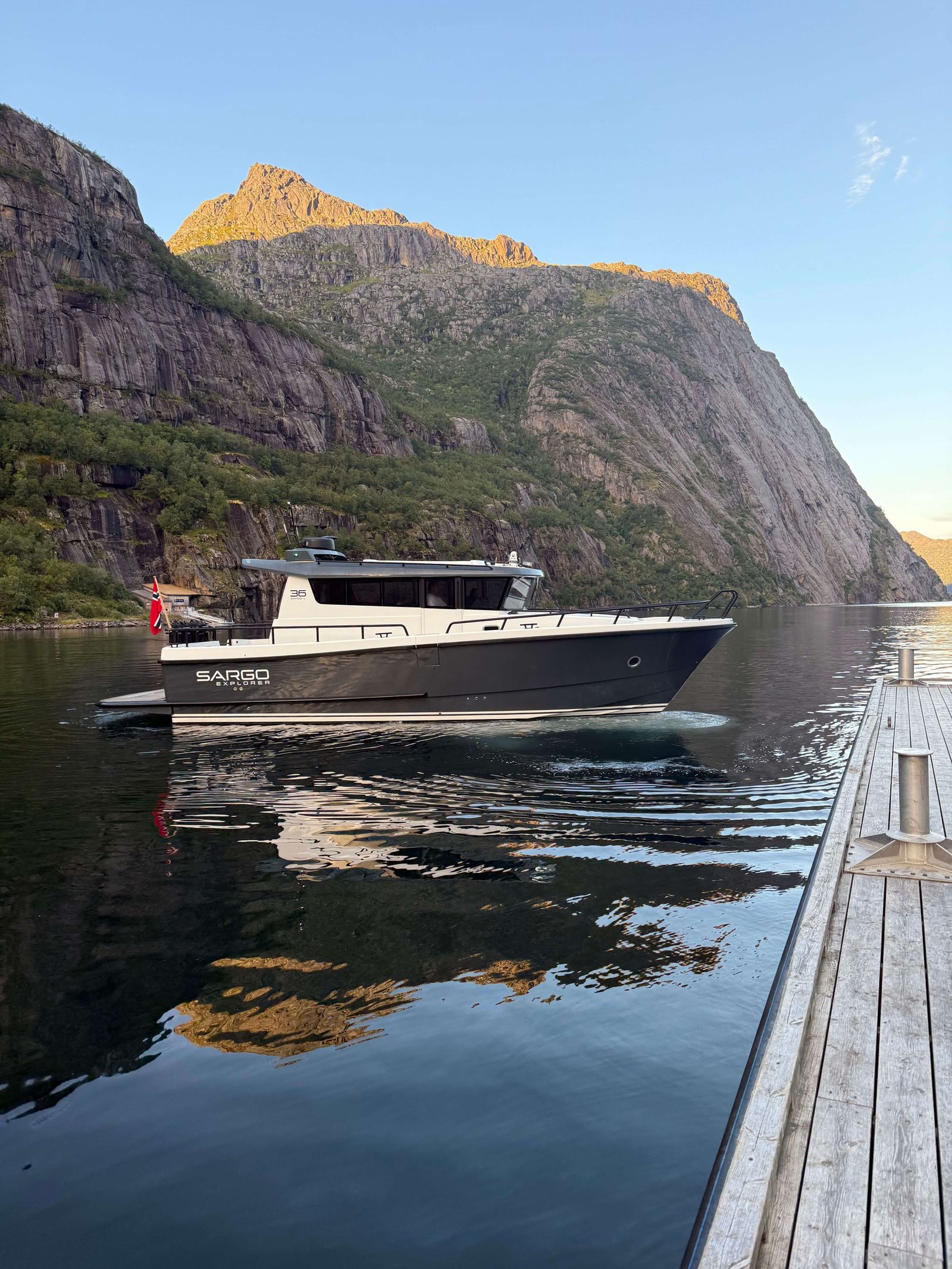 Lyngen Lady ved kai med solbelyst fjelltopp bak