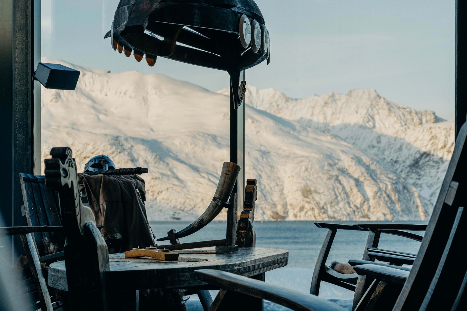Utsikt fra styrhuset mot snødekte fjell over fjorden
